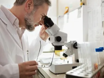 man looking through microscope