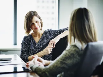 Two people having a seated conversation at work.