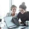 Smiling colleagues looking at a laptop 